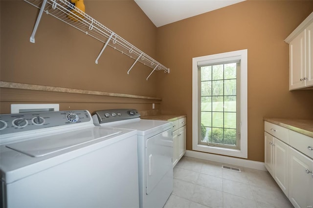 laundry room featuring light tile patterned floors, cabinet space, baseboards, visible vents, and washer and clothes dryer