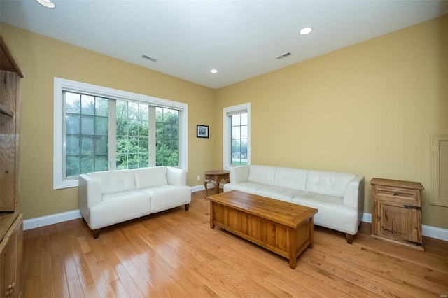 living area with recessed lighting, visible vents, light wood-style flooring, and baseboards
