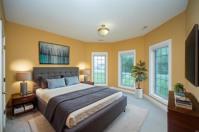 carpeted bedroom with visible vents and multiple windows