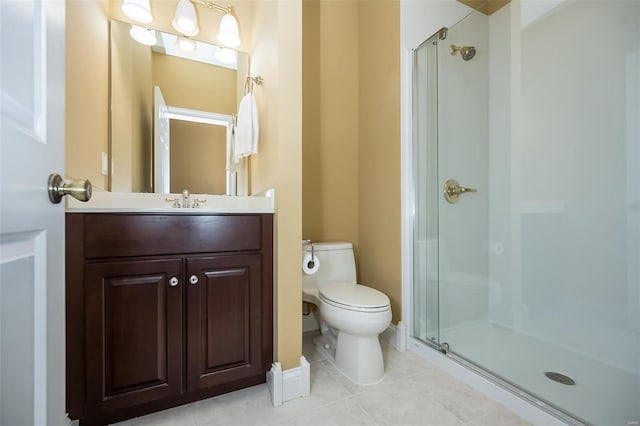 bathroom featuring tile patterned floors, toilet, vanity, and a shower stall