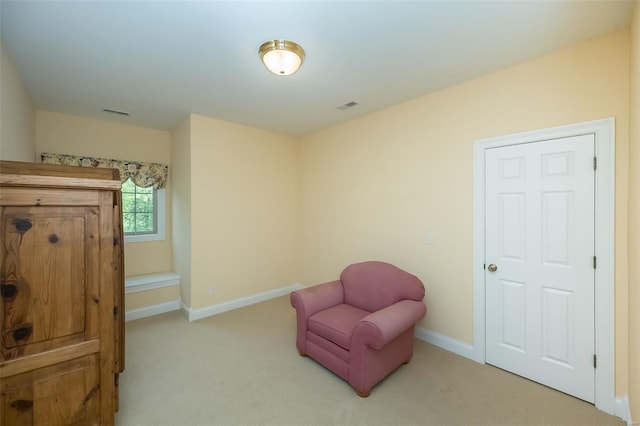 living area with baseboards, visible vents, and carpet