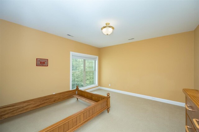 interior space featuring baseboards, visible vents, and light colored carpet
