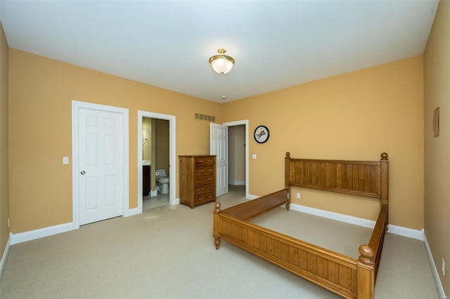 bedroom featuring visible vents, baseboards, ensuite bath, and light carpet