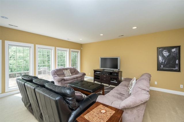 carpeted living area with a wealth of natural light, visible vents, recessed lighting, and baseboards