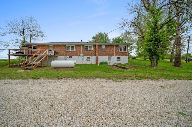 back of house featuring brick siding, a yard, stairway, a wooden deck, and a chimney