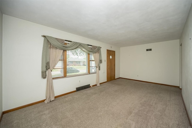 carpeted spare room featuring visible vents and baseboards