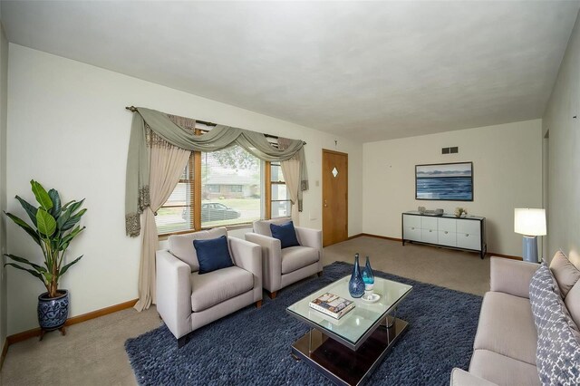 living area featuring visible vents, carpet floors, and baseboards