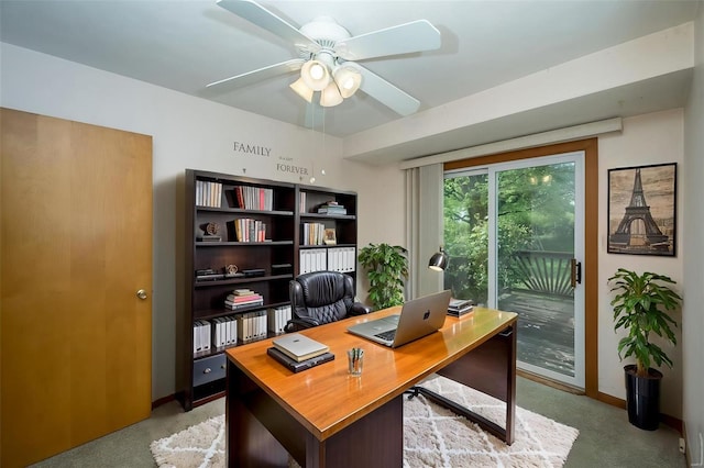 office space featuring a ceiling fan, light colored carpet, and baseboards