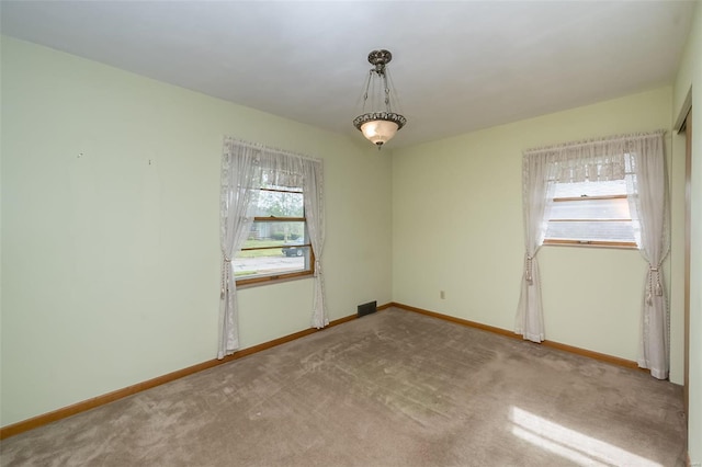 unfurnished room with carpet and baseboards