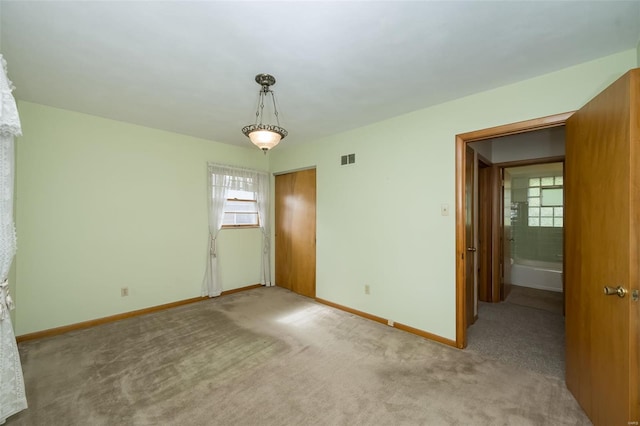 spare room featuring baseboards, visible vents, and carpet floors