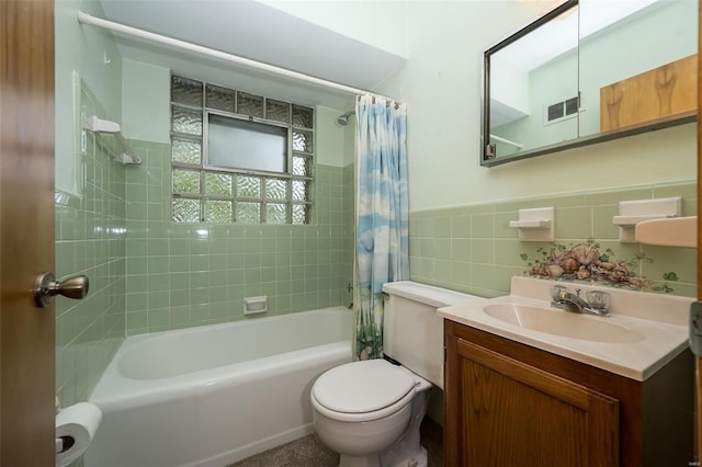 full bathroom featuring tile walls, shower / bath combo with shower curtain, toilet, vanity, and visible vents