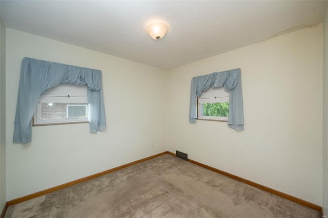carpeted empty room featuring baseboards