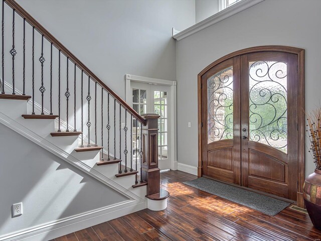 entryway with hardwood / wood-style floors, baseboards, a towering ceiling, french doors, and stairs