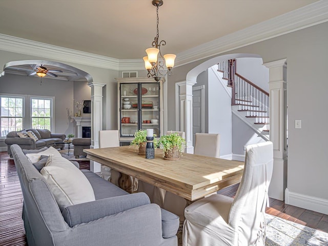 dining space featuring wood finished floors, ceiling fan, baseboards, ornate columns, and crown molding