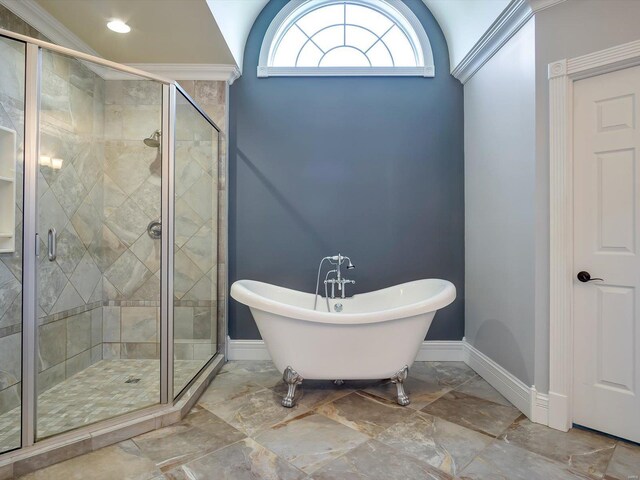 full bathroom featuring a shower stall, a freestanding bath, and baseboards
