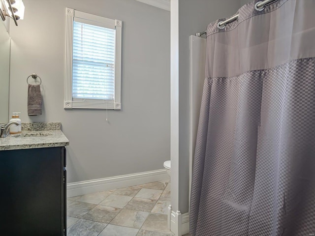bathroom featuring baseboards, a shower with shower curtain, toilet, and vanity