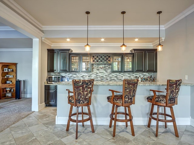 kitchen featuring a kitchen breakfast bar, stainless steel microwave, glass insert cabinets, and backsplash
