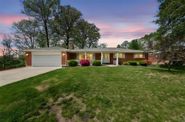 ranch-style home with a lawn, concrete driveway, a porch, and an attached garage