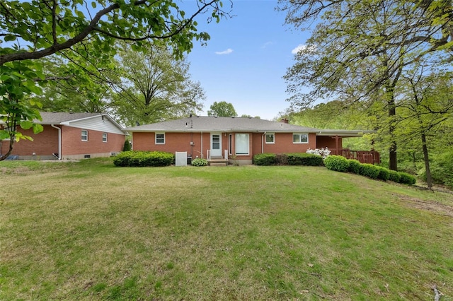 rear view of house featuring cooling unit, a lawn, and brick siding