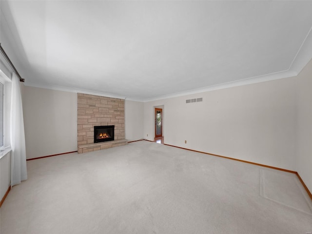unfurnished living room featuring baseboards, visible vents, carpet floors, and crown molding