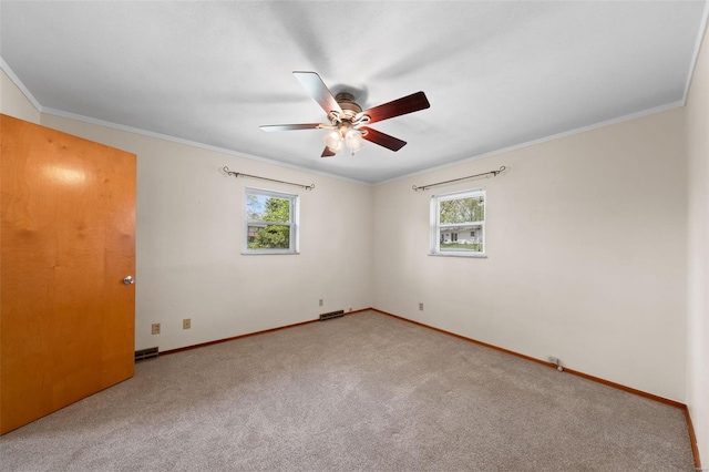 carpeted spare room featuring visible vents, a ceiling fan, ornamental molding, and baseboards
