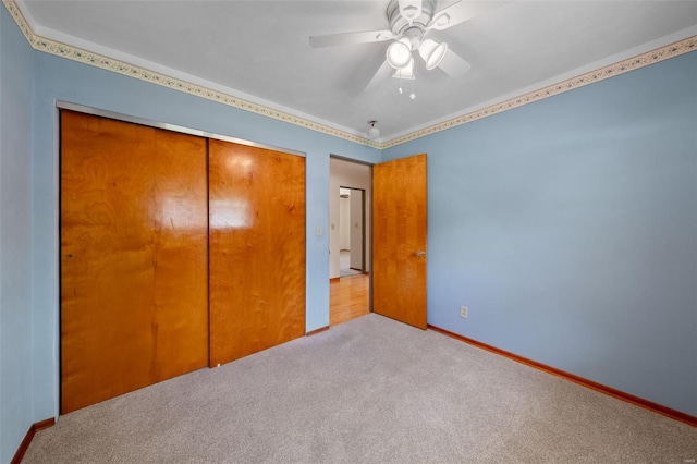 unfurnished bedroom featuring carpet, baseboards, a ceiling fan, and a closet