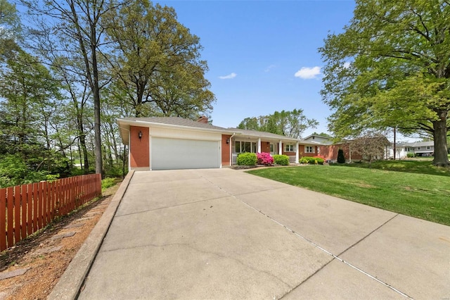 single story home with driveway, an attached garage, fence, brick siding, and a front lawn
