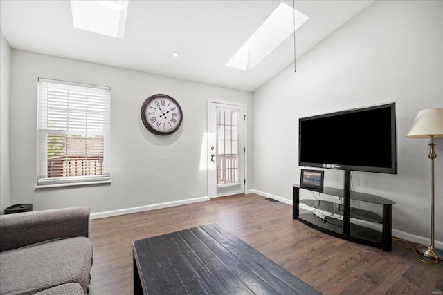 living area featuring baseboards, wood finished floors, and vaulted ceiling with skylight