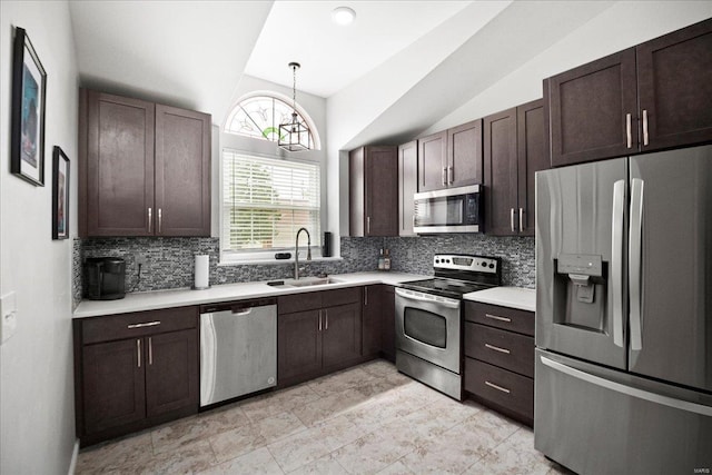 kitchen with vaulted ceiling, a sink, backsplash, and appliances with stainless steel finishes