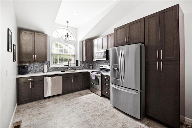 kitchen featuring backsplash, vaulted ceiling, stainless steel appliances, and a sink