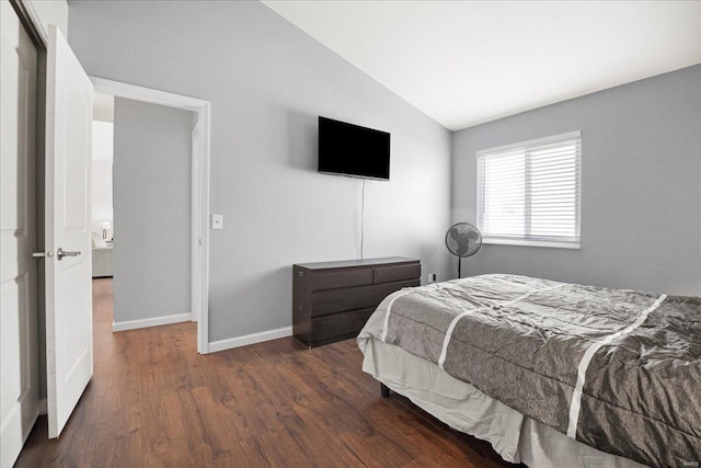 bedroom with lofted ceiling, baseboards, and wood finished floors