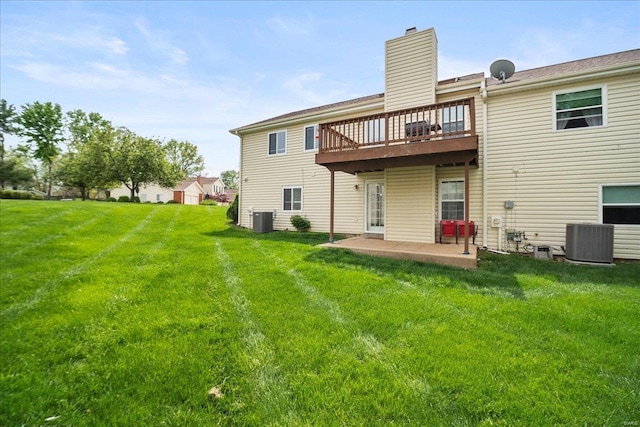 rear view of property featuring a lawn, a patio area, and cooling unit
