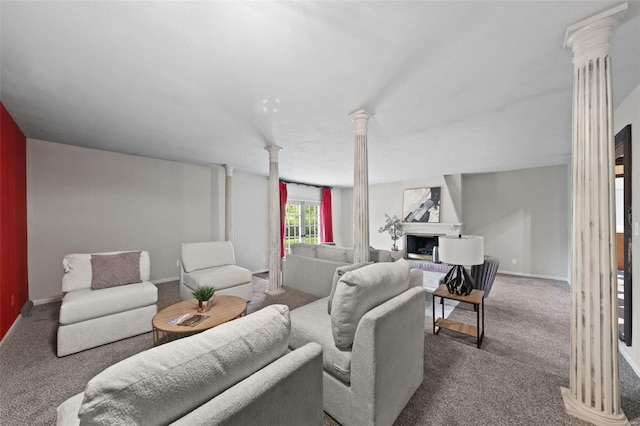 carpeted living area featuring ornate columns, a fireplace with raised hearth, and baseboards