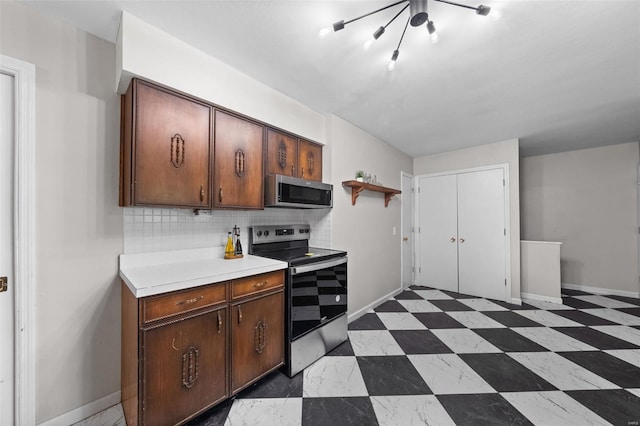kitchen featuring open shelves, decorative backsplash, appliances with stainless steel finishes, light countertops, and baseboards