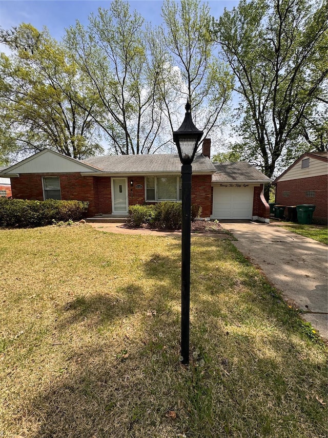 ranch-style house featuring a chimney, brick siding, a front yard, and concrete driveway