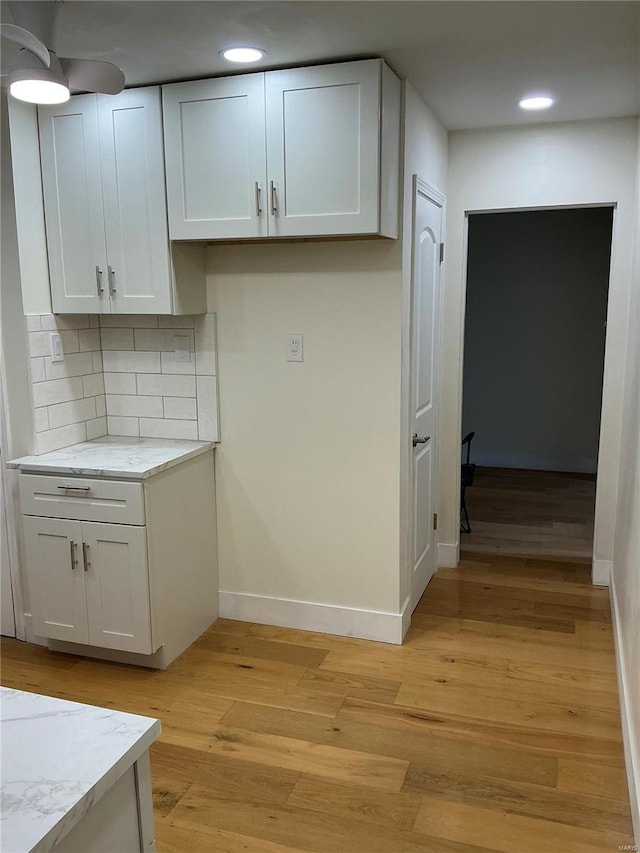 kitchen with baseboards, white cabinets, and light wood finished floors