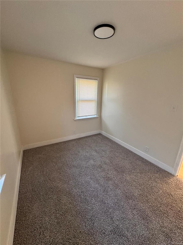 carpeted spare room featuring baseboards