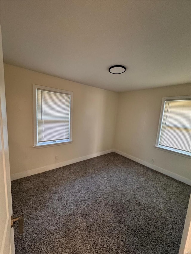 empty room featuring a healthy amount of sunlight, carpet flooring, and baseboards