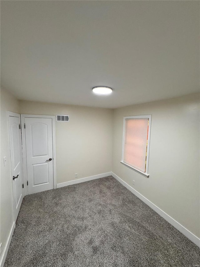 spare room with baseboards, visible vents, and carpet flooring