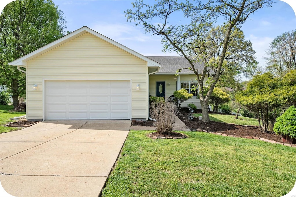 single story home with concrete driveway, a front yard, and an attached garage