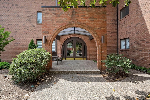 doorway to property featuring brick siding and french doors