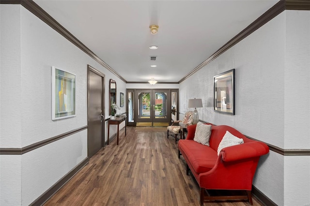 hall featuring a textured wall, ornamental molding, wood finished floors, and visible vents