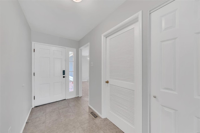 entryway with baseboards, visible vents, and light tile patterned floors