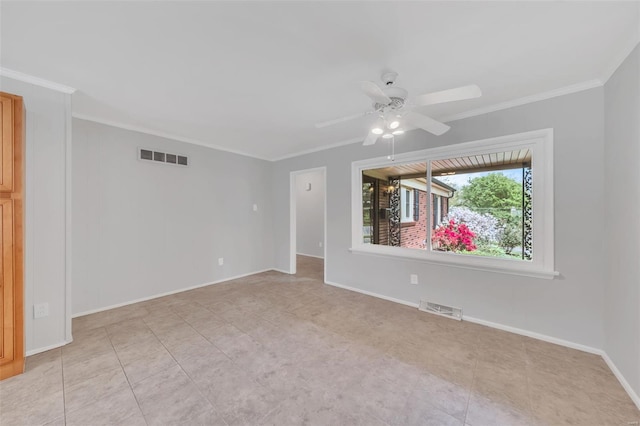 spare room with visible vents, a ceiling fan, ornamental molding, and baseboards