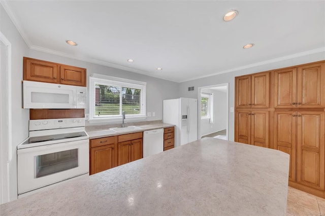 kitchen with a healthy amount of sunlight, ornamental molding, white appliances, and a sink