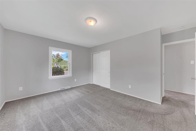 unfurnished room with baseboards, visible vents, and carpet flooring