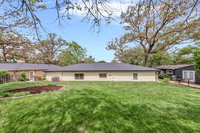 back of house featuring a lawn and central air condition unit