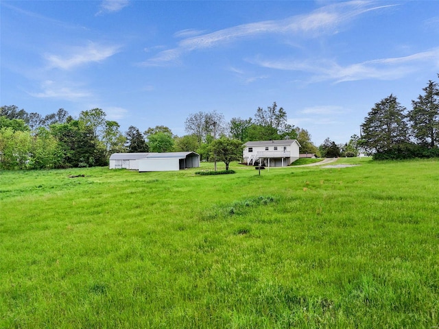 view of yard with a rural view and an outdoor structure