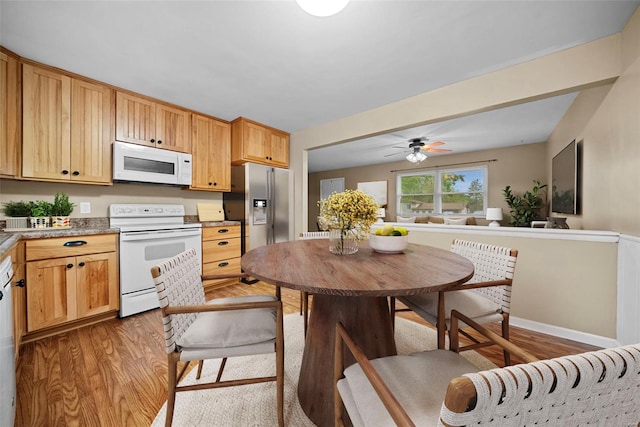 kitchen featuring light wood-style floors, a ceiling fan, and white appliances
