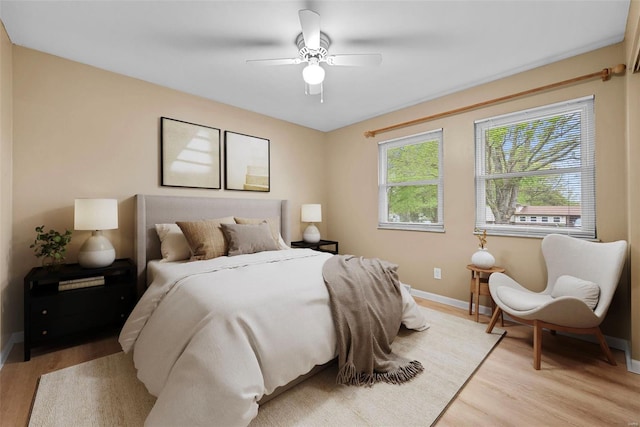 bedroom with baseboards, ceiling fan, and light wood-type flooring